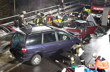 Blick auf die beiden am Unfall beteiligten Fahrzeuge, Polizisten untersuchen eins der Fahrzeuge